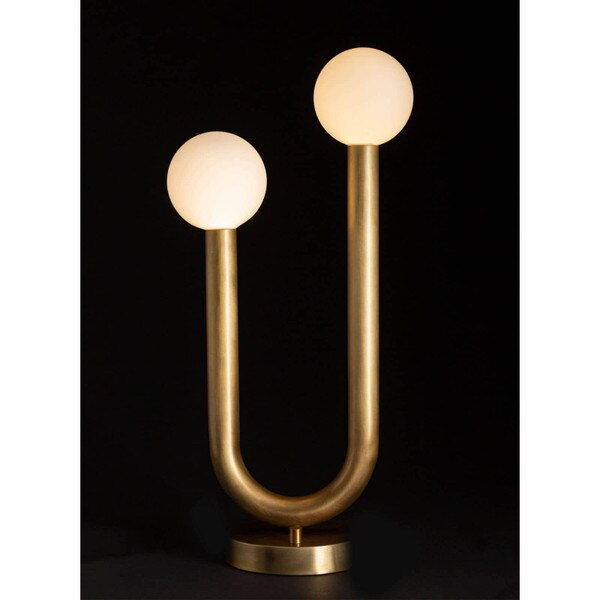 natural brass table lamp with two arms and circular bulbs in front of a black background